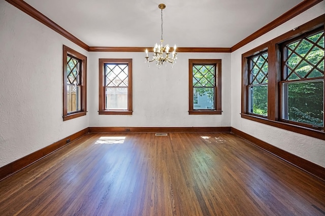 2067 Hallwood Dr, Memphis, TN 38107 - empty room with dark wood finished floors, plenty of natural light, a chandelier, crown molding, and a textured wall