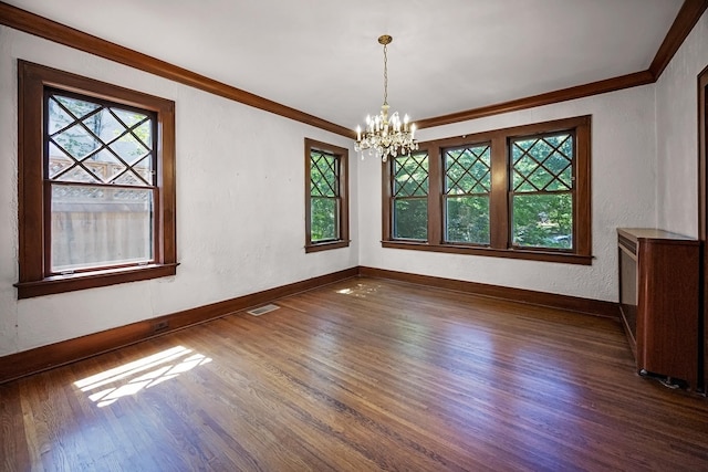 2067 Hallwood Dr, Memphis, TN 38107 - empty room with crown molding, dark wood-style floors, a chandelier, healthy amount of natural light, and a textured wall