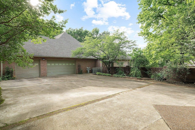 6500 State Line Rd, Tn, TN 38141 - view of side of property with concrete driveway, roof with shingles, an attached garage, and brick siding