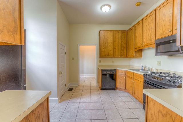 1692 Carruthers Pl, Memphis, TN 38112 - kitchen featuring black dishwasher, stainless steel microwave, gas range, light countertops, and light tile patterned floors