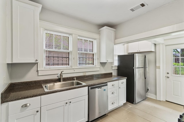 730 Maury St, Memphis, TN 38107 - kitchen with stainless steel appliances, dark countertops, white cabinetry, and light wood-type flooring