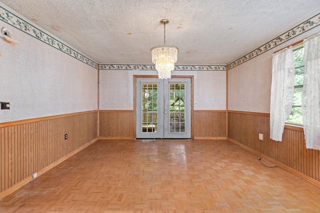 18 County Road 252nd Rd, Glen, MS 38846 - spare room featuring a chandelier, a wainscoted wall, a textured ceiling, wooden walls, and french doors