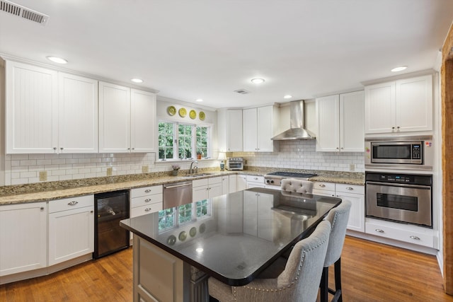 215 Belhaven St, Memphis, TN 38117 - kitchen featuring stainless steel appliances, wall chimney range hood, wine cooler, light wood-style flooring, and recessed lighting