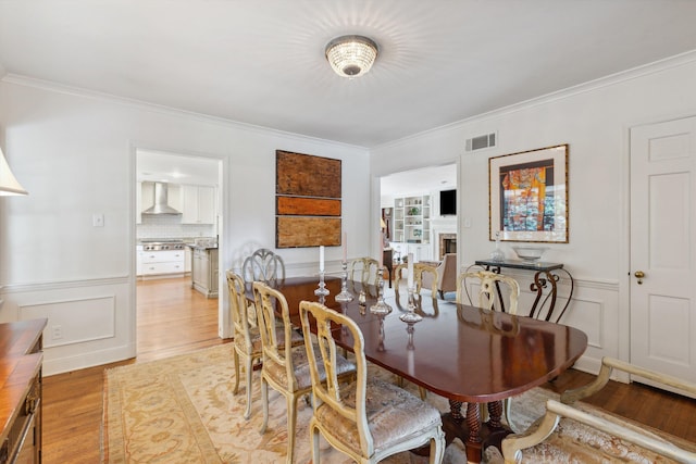 215 Belhaven St, Memphis, TN 38117 - dining room with ornamental molding, light wood-type flooring, and a fireplace