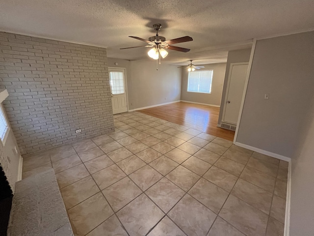 4080 Northbridge Ave, Memphis, TN 38118 - spare room with brick wall, a textured ceiling, a ceiling fan, and light tile patterned floors