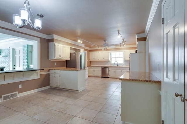 2030 Quail Creek Cv, Memphis, TN 38119 - kitchen with light tile patterned floors, a peninsula, stainless steel appliances, rail lighting, and a chandelier
