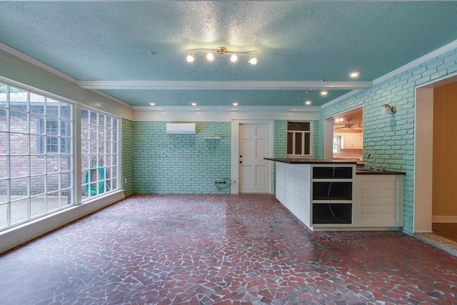 2030 Quail Creek Cv, Memphis, TN 38119 - unfurnished living room featuring brick wall, ornamental molding, and a textured ceiling