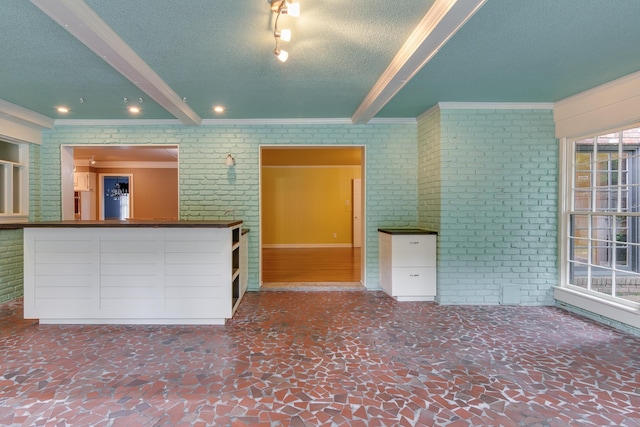 2030 Quail Creek Cv, Memphis, TN 38119 - unfurnished living room featuring ornamental molding, brick wall, a textured ceiling, beamed ceiling, and recessed lighting
