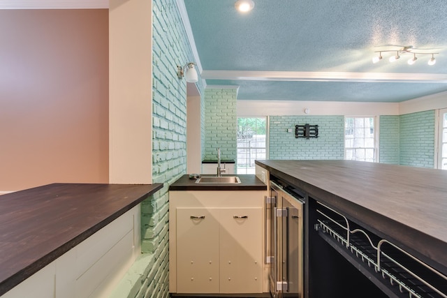 2030 Quail Creek Cv, Memphis, TN 38119 - kitchen with ornamental molding, a textured ceiling, white cabinetry, healthy amount of natural light, and wine cooler