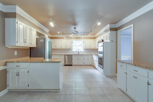 2030 Quail Creek Cv, Memphis, TN 38119 - kitchen with appliances with stainless steel finishes, rail lighting, ceiling fan, a peninsula, and crown molding