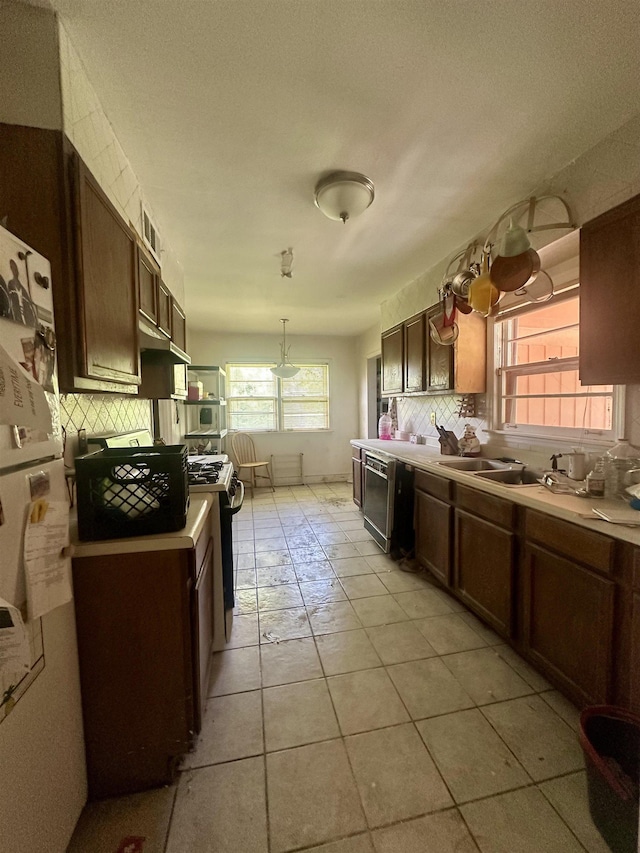 1407 Worthington St, Memphis, TN 38114 - kitchen featuring backsplash, range with gas cooktop, dishwashing machine, light tile patterned floors, and freestanding refrigerator