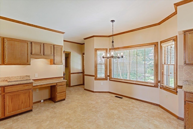 7802 Foster Ridge Dr, Germantown, TN 38138 - kitchen with built in study area, plenty of natural light, a chandelier, crown molding, and decorative light fixtures