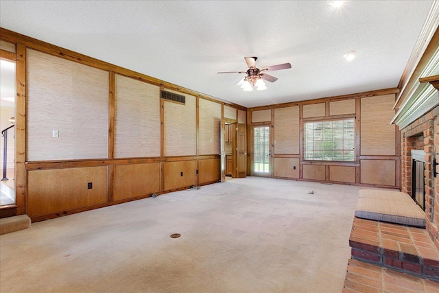 7802 Foster Ridge Dr, Germantown, TN 38138 - unfurnished living room featuring a ceiling fan, a brick fireplace, light carpet, a decorative wall, and a textured ceiling