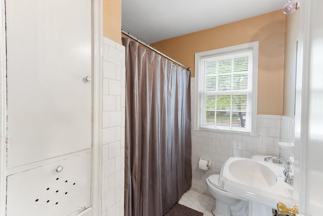 3541 Aurora Cir, Memphis, TN 38111 - bathroom with tile walls, tile patterned floors, curtained shower, and a wainscoted wall