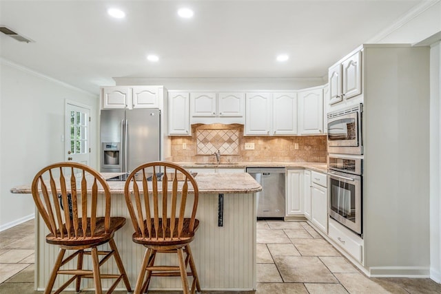 2108 Prestwick Dr, Germantown, TN 38139 - kitchen with appliances with stainless steel finishes, crown molding, a center island, decorative backsplash, and a kitchen bar