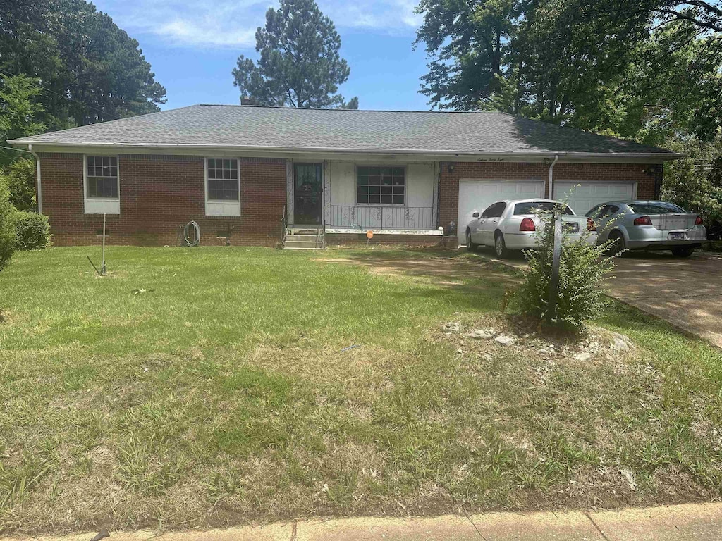 1638 Hester Dr, Memphis, TN 38116 - single story home with an attached garage, a front yard, driveway, and brick siding