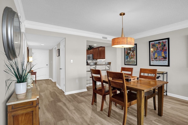 200 Wagner Pl Unit 804, Memphis, TN 38103 - dining area with light wood-style floors and crown molding