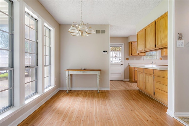 3333 Sycamore View Rd, Bartlett, TN 38134 - kitchen featuring a chandelier, light wood finished floors, a textured ceiling, light countertops, and hanging light fixtures