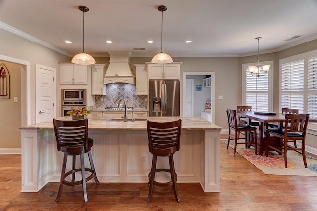 280 Cotton Trail Dr, Rossville, TN 38066 - kitchen featuring stainless steel appliances, premium range hood, backsplash, light wood-type flooring, and a kitchen island with sink