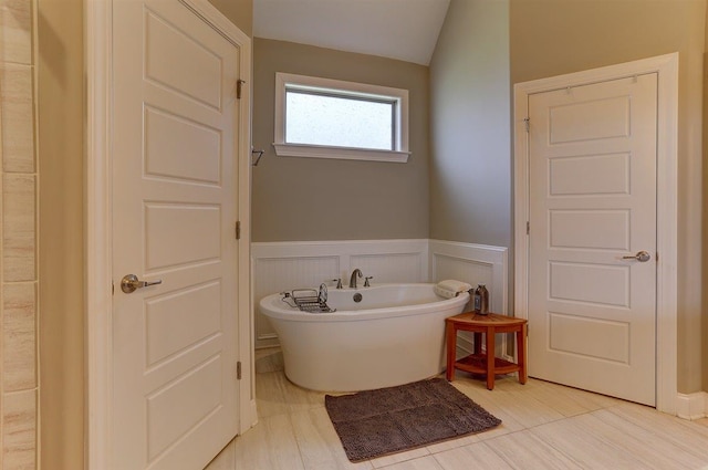 280 Cotton Trail Dr, Rossville, TN 38066 - bathroom with a freestanding bath, a wainscoted wall, a decorative wall, and lofted ceiling