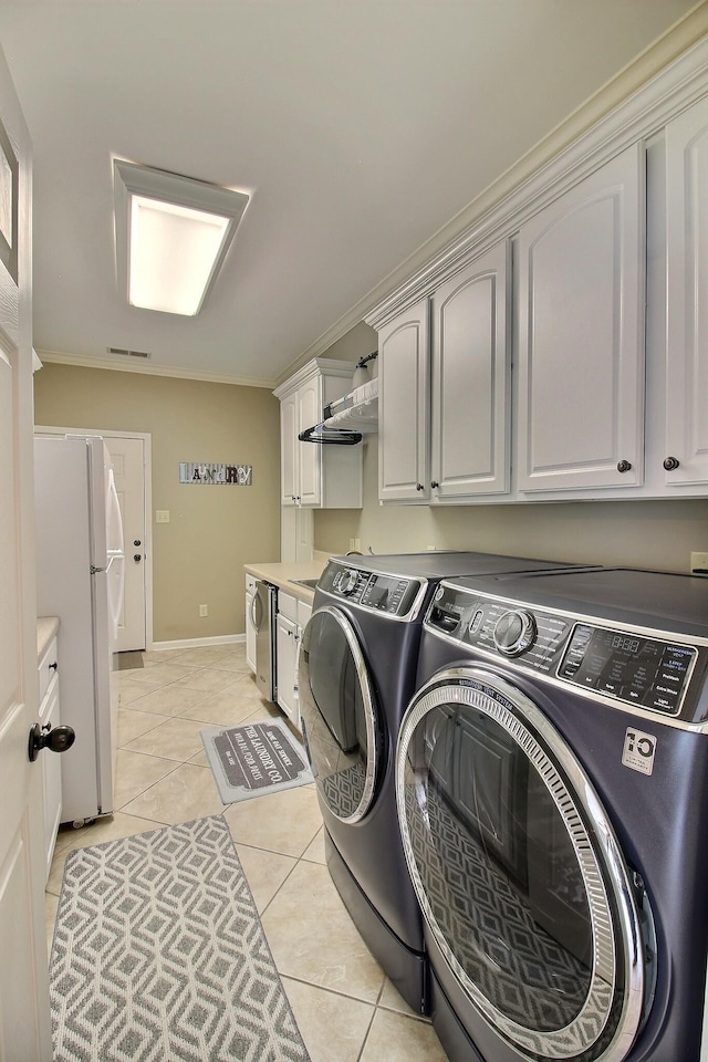 774 Wellington Way Cv, Collierville, TN 38017 - laundry area with washing machine and dryer, cabinet space, light tile patterned flooring, and ornamental molding