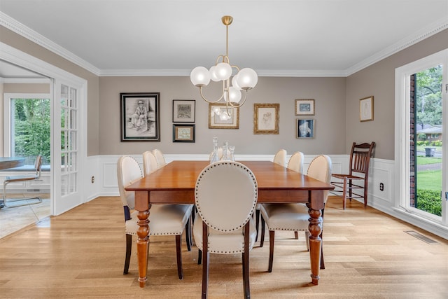 2004 Kirby Rd, Memphis, TN 38119 - dining area with light wood-style flooring, crown molding, a decorative wall, a chandelier, and a wainscoted wall