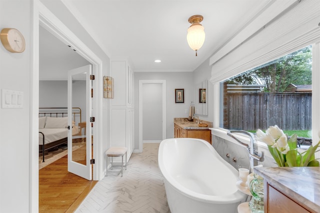 2004 Kirby Rd, Memphis, TN 38119 - bathroom with vanity, a freestanding tub, ornamental molding, and recessed lighting