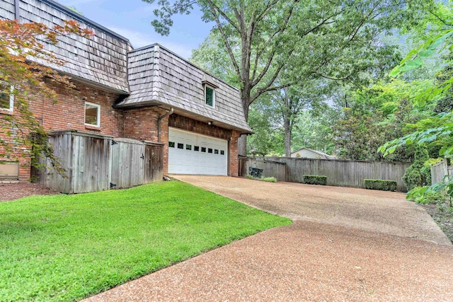 2004 Kirby Rd, Memphis, TN 38119 - view of property exterior featuring mansard roof, brick siding, driveway, and a garage