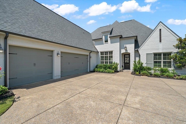 4741 Carousel Ln, Collierville, TN 38017 - french country home with concrete driveway, roof with shingles, brick siding, and an attached garage