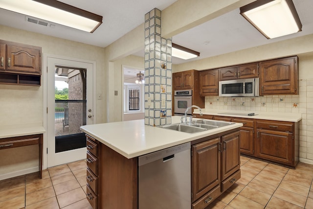 460 Jason Dr, Memphis, TN 38120 - kitchen featuring appliances with stainless steel finishes, light tile patterned floors, light countertops, and a kitchen island with sink