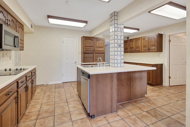 460 Jason Dr, Memphis, TN 38120 - kitchen featuring stainless steel appliances, tasteful backsplash, light countertops, a center island with sink, and light tile patterned flooring