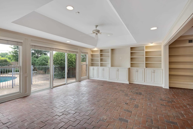 460 Jason Dr, Memphis, TN 38120 - empty room with a tray ceiling, a ceiling fan, recessed lighting, brick flooring, and built in shelves
