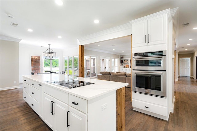 2165 Latting Hills Cv, Eads, TN 38016 - kitchen with double oven, black electric stovetop, ornamental molding, dark wood finished floors, and white cabinetry