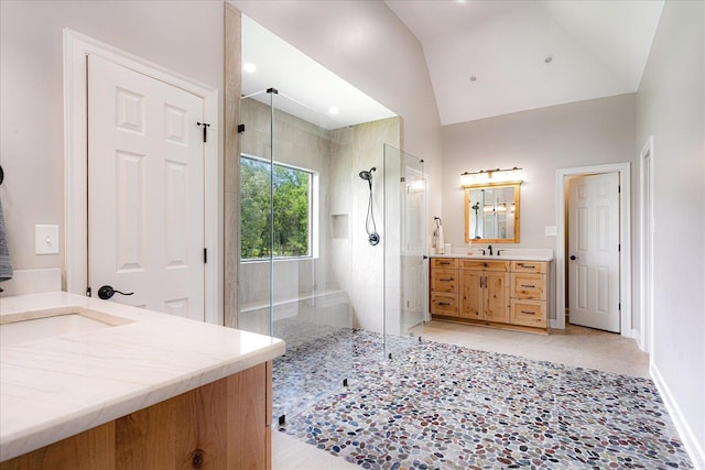 2165 Latting Hills Cv, Eads, TN 38016 - bathroom featuring a tile shower, two vanities, lofted ceiling, and tile patterned floors