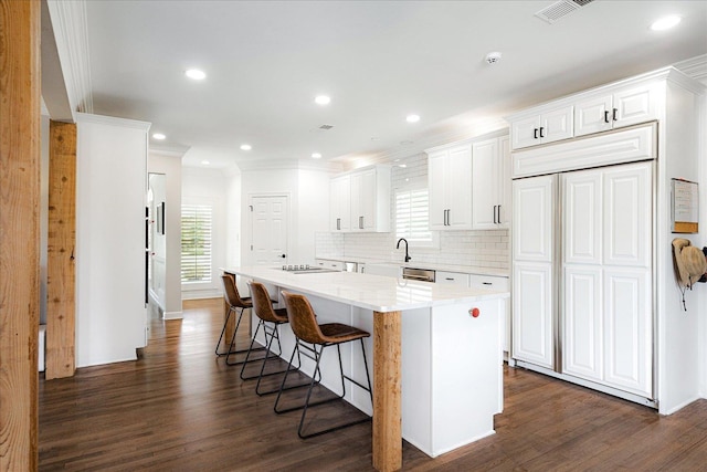 2165 Latting Hills Cv, Eads, TN 38016 - kitchen featuring crown molding, a kitchen island, dark wood-style floors, a breakfast bar, and decorative backsplash