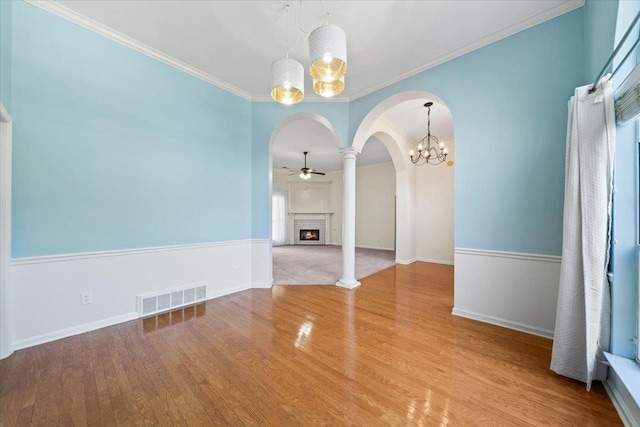 3760 Broadway Rd, Bartlett, TN 38135 - unfurnished dining area featuring arched walkways, a ceiling fan, a chandelier, a fireplace, and wood finished floors
