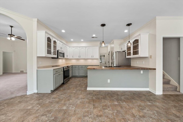 3760 Broadway Rd, Bartlett, TN 38135 - kitchen featuring stainless steel appliances, a peninsula, glass insert cabinets, a ceiling fan, and butcher block countertops