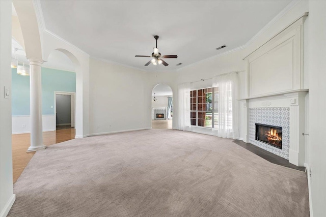 3760 Broadway Rd, Bartlett, TN 38135 - unfurnished living room featuring a tiled fireplace, ceiling fan, ornamental molding, light carpet, and arched walkways