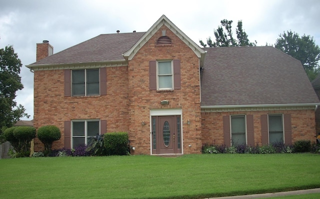 4294 Thunderstone Cir W, Memphis, TN 38125 - view of front of house with a chimney, a shingled roof, a front yard, and brick siding
