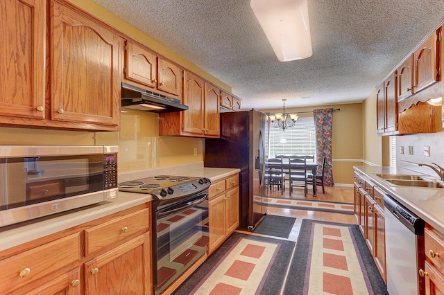 3365 Harrell Rd, Tn, TN 38002 - kitchen with under cabinet range hood, appliances with stainless steel finishes, a textured ceiling, light countertops, and a chandelier