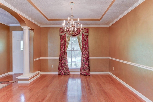 3365 Harrell Rd, Tn, TN 38002 - unfurnished room with arched walkways, wood finished floors, ornate columns, a textured ceiling, and a chandelier