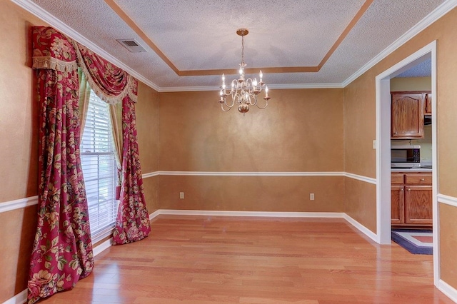 3365 Harrell Rd, Tn, TN 38002 - unfurnished room featuring light wood finished floors, a chandelier, a textured ceiling, and a raised ceiling