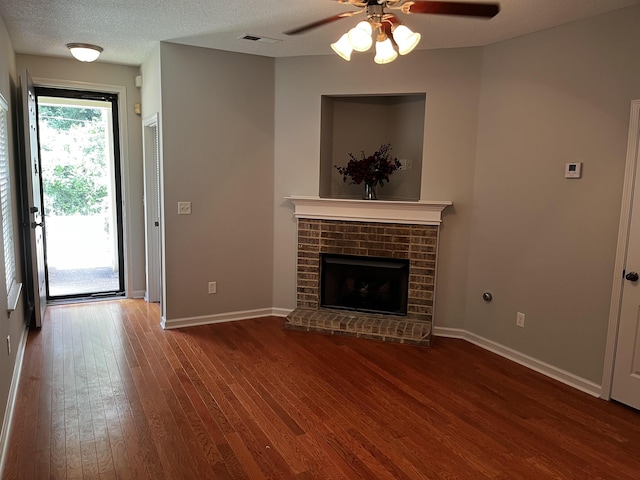 1182 Collierville-Arlington Rd, Collierville, TN 38017 - unfurnished living room with wood finished floors, a ceiling fan, a fireplace, and a textured ceiling