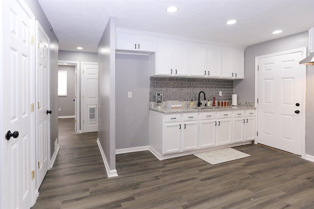 518 Jenson Rd, Memphis, TN 38109 - kitchen with white cabinetry, dark wood finished floors, decorative backsplash, light stone countertops, and recessed lighting