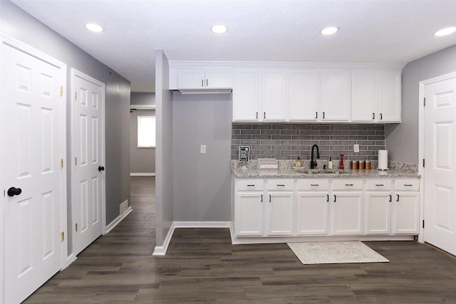 518 Jenson Rd, Memphis, TN 38109 - kitchen with white cabinetry, tasteful backsplash, dark wood-style floors, light stone counters, and recessed lighting