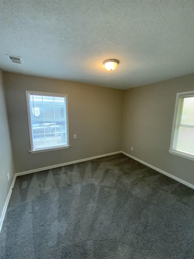 3560 Steele St, Memphis, TN 38127 - spare room with a textured ceiling and dark carpet