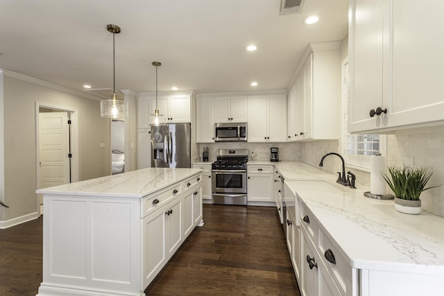 3613 Charleswood Ave, Memphis, TN 38122 - kitchen featuring stainless steel appliances, decorative backsplash, white cabinets, ornamental molding, and recessed lighting