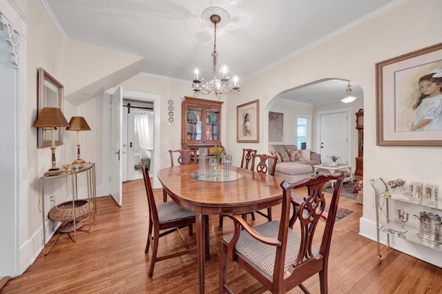 560 S Greer St, Memphis, TN 38111 - dining space featuring arched walkways, light wood-style flooring, a chandelier, and ornamental molding