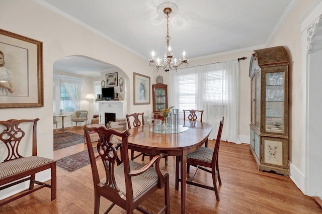 560 S Greer St, Memphis, TN 38111 - dining area featuring arched walkways, light wood finished floors, a chandelier, and ornamental molding