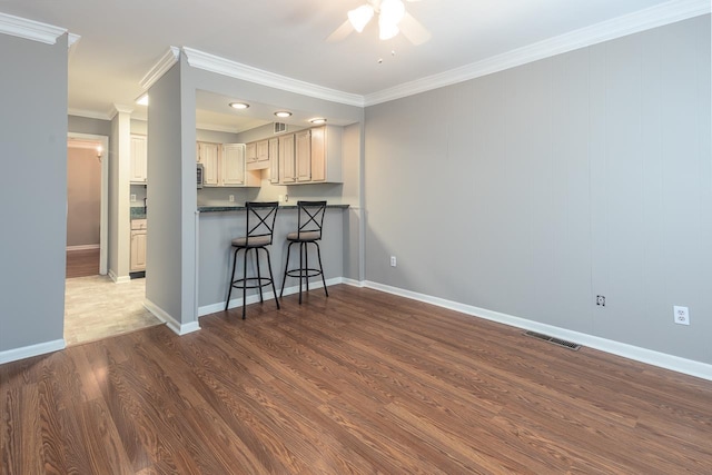 6942 Amberly Rd Unit 6942, Memphis, TN 38119 - kitchen featuring ceiling fan, wood finished floors, a breakfast bar area, ornamental molding, and dark countertops